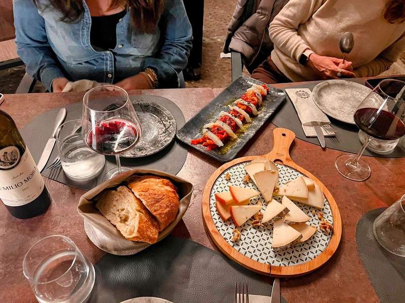 A dinner spread in Spain with glasses of Emilio Moro wine.