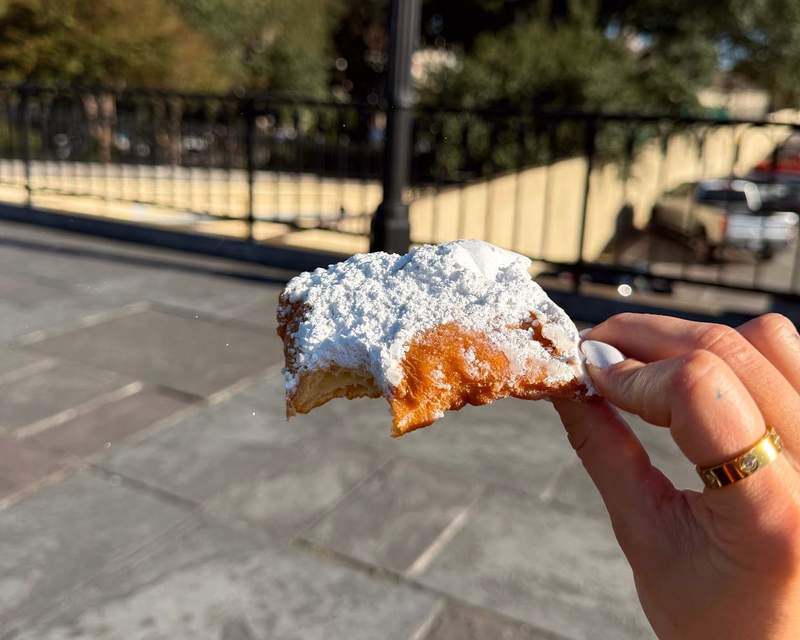 Author holding a beignet in New Orleans.