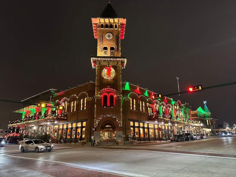A large corner building decorated with red and green lights.