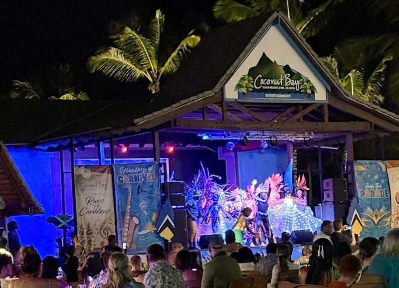 Outdoor stage at Coconut Bay decorated for Caribbean Night with colorful dancers and lights.