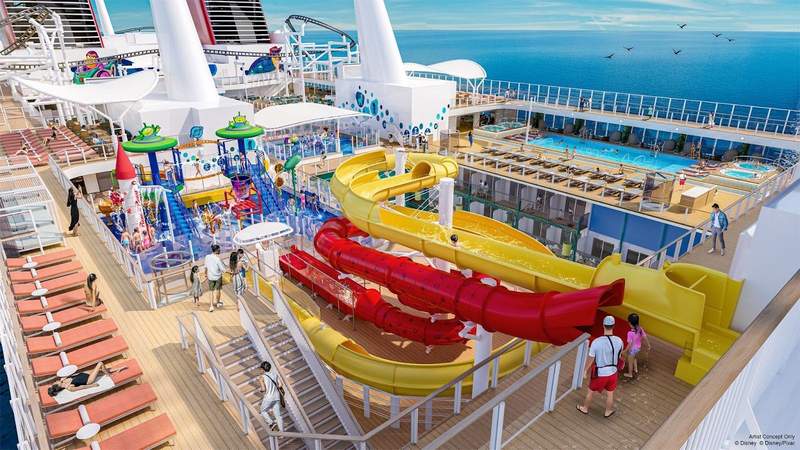Bright yellow and red waterslides an expansive water play area and pools with lounge chairs can be seen on the top decks of Disney Cruise Lines newest ship Disney Adventure.