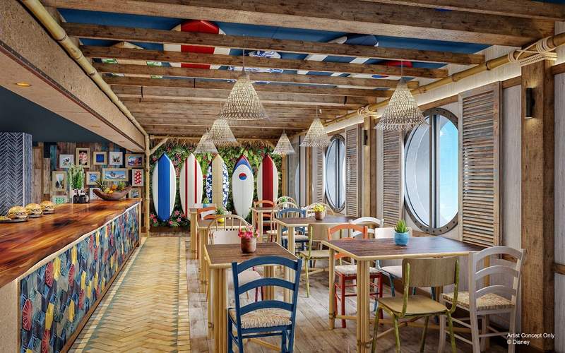 The interior of a beachy surf themed casual dining restaurant with tables and brightly colored chairs. Surfboards adorn the walls and sun shines through large circular windows. 