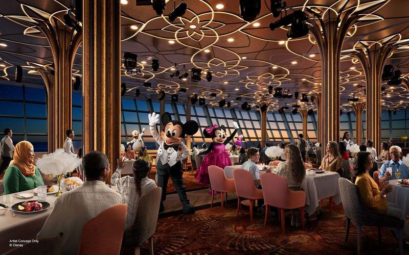 Families dine in Disney Adventures new rotational dining room Hollywood Spotlight Club featuring richly patterned lights across the ceiling and patterned orange rugs. Mickey Mouse and Minnie Mouse are smartly dressed in a tuxedo and pink dress waving to guests.