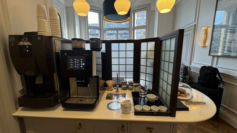 coffee and espresso machines with pastries in a white dish and a black window at righ residences edinburgh