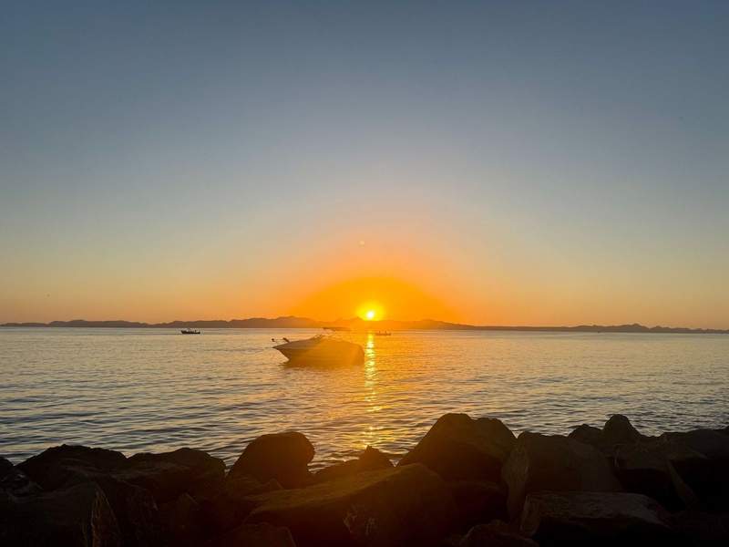 Sunrise over the sea with a boat in the foreground