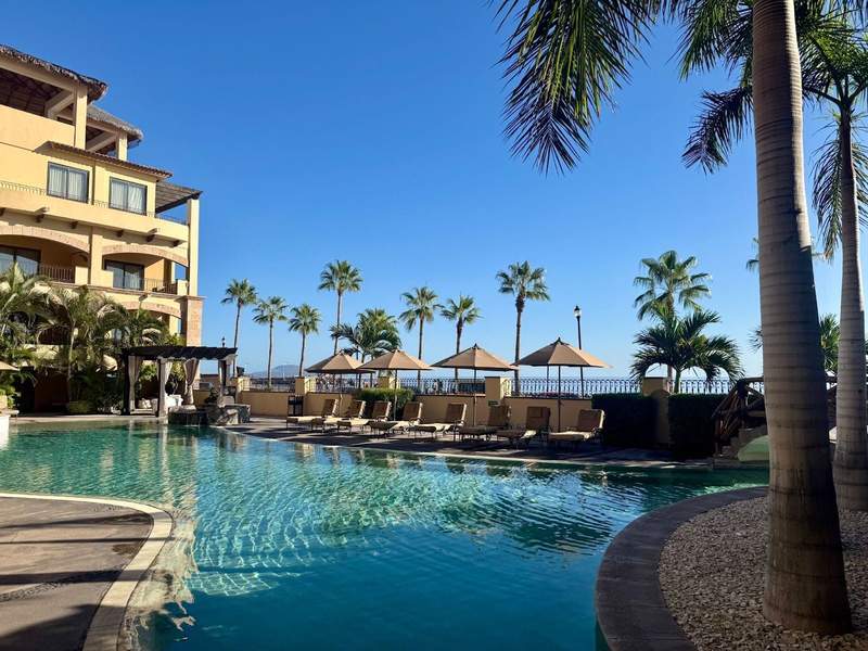A hotel pool reflecting palm trees