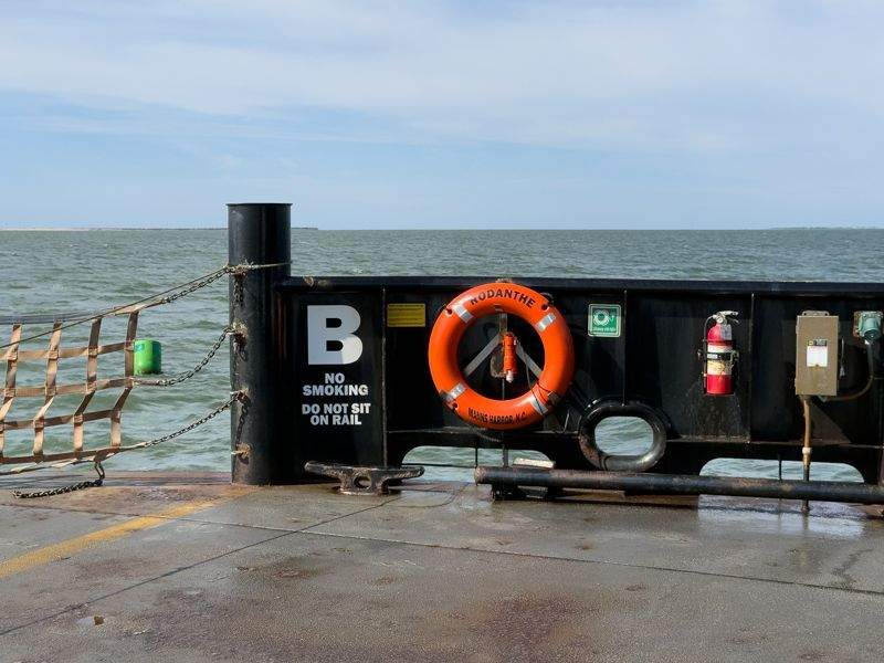 Outer Banks vehicle and passenger ferry cruising across Pamlico Sound with low islands on the horizon. 