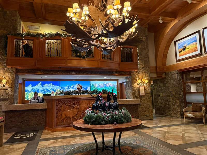 The lobby area and front desk at the Wyoming Inn in Jackson Hole features an antler chandalier and wildlife photos.