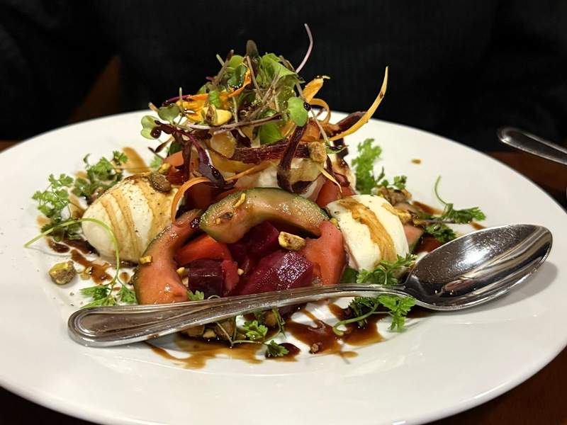 Burrata salad at The Whistling Grizzly Restaurant in Jackson Hole features colorful ingredients.