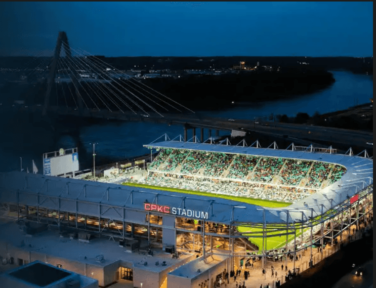 CPKC stadium lit up at night with river flowing in the background