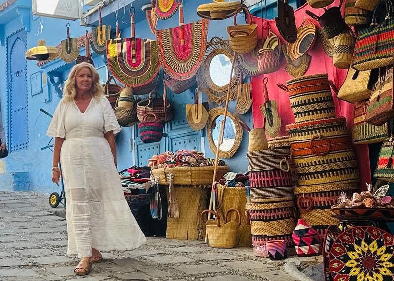 A woman walking through the medina toward her riad in Chefchaouen Morocco
