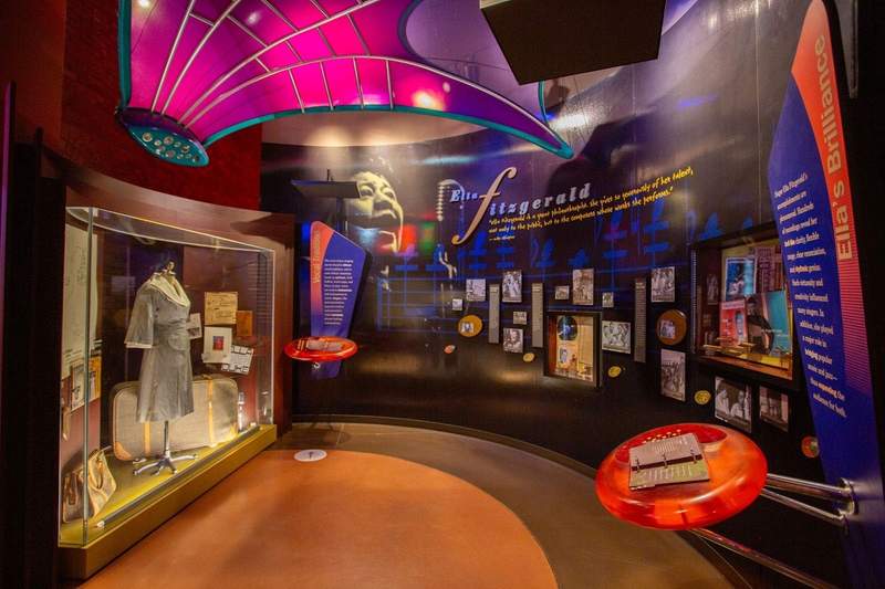 A dress from the Golden Age of jazz is situated in an interactive hall which features listening booths.