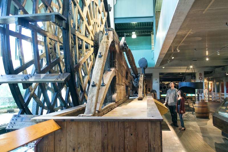 Giant paddlewheel of a steamboat on display at a museum of steamboat artifacts.