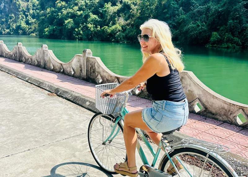 A woman riding a bicycle on Cat Ba Island in Vietnam