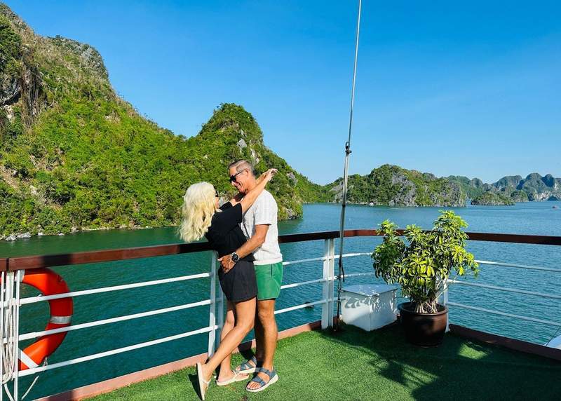 A couple standing together on the deck of a cruise ship in Ha Long Bay Vietnam