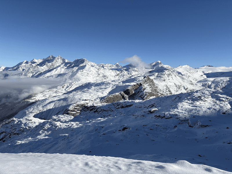 Snow capped mountains with clouds hanging below the peaks