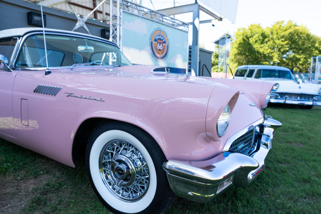 Two classic cars at the Admiral Twin Drive-in in Tulsa, parked during the Capital Cruise Route 66 Centennial announcement.