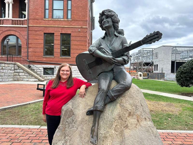 A lady beside the Dolly Parton Statue.