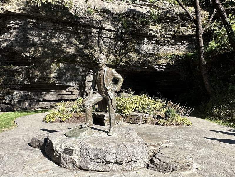 A statue of a man with his foot on a barrel.