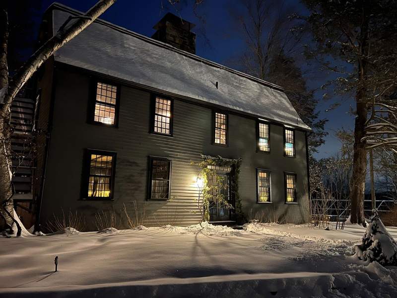 The exterior of the Lost Fox Inn in Litchfield CT at nighttime covered in snow.