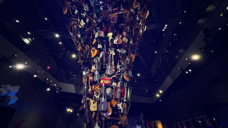 stack of guitars on display in a room with yellow spotlights at the Museum of Pop Culture in Seattle