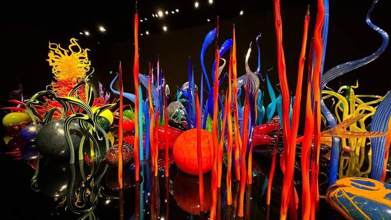 Colorful red blue yellow and green glass blown sticks and circles on display at Chihuly Garden and Glass. 