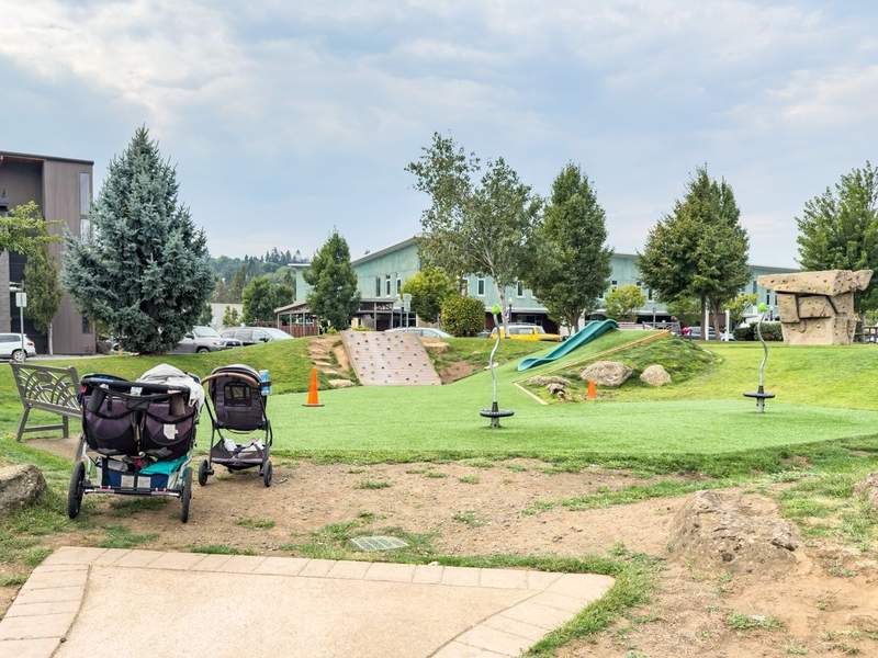 playground with strollers and green space for kids to play on