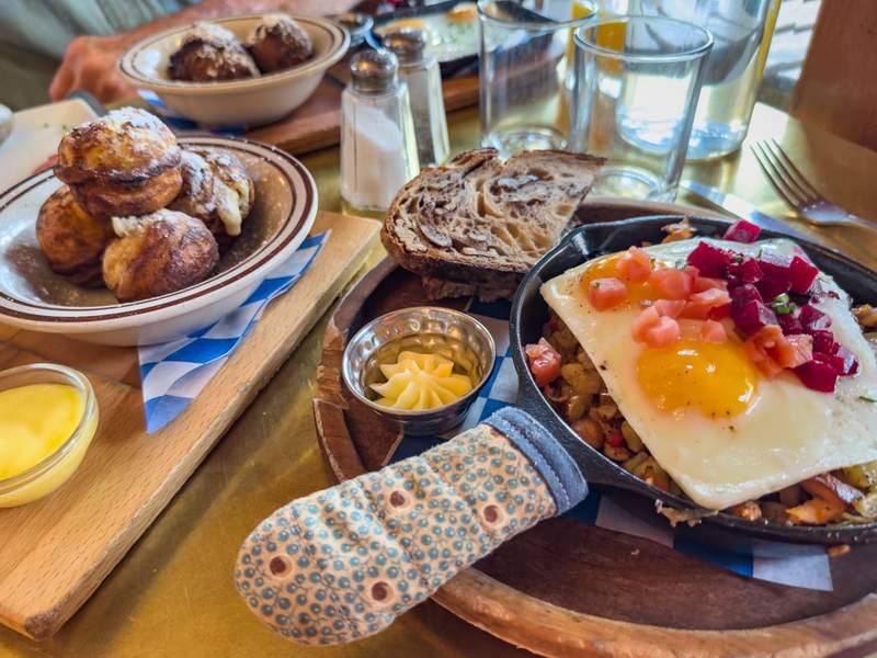 A breakfast meal at Broder Ost with eggs in a skillet walnut toast and other Scandinavian delicacies.