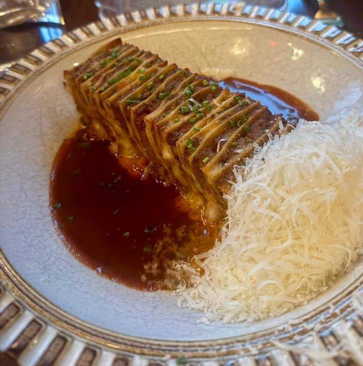 A plate featuring LArdentes 40 layer lasagna showcasing layers of pasta meat and cheese