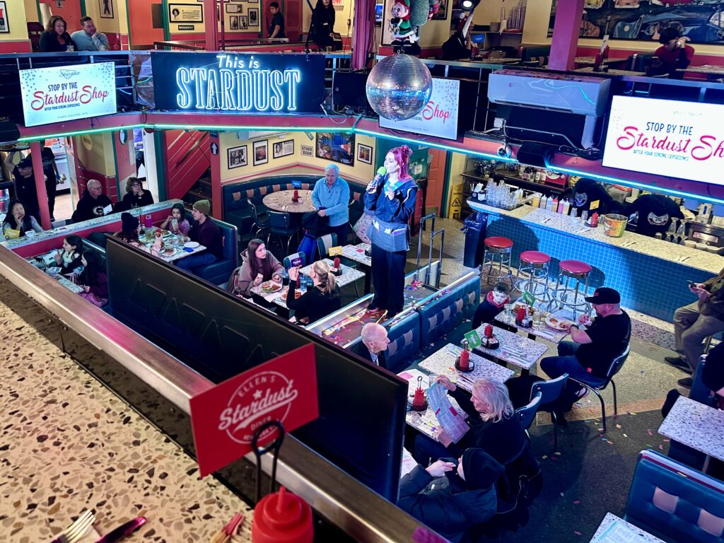 Waitress singing in the middle of Ellen's Stardust Diner, a classic venue in New York's Times Square.