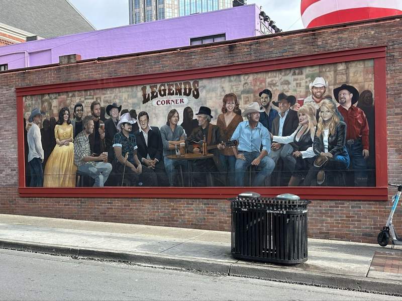 A mural of country music stars on a wall. 