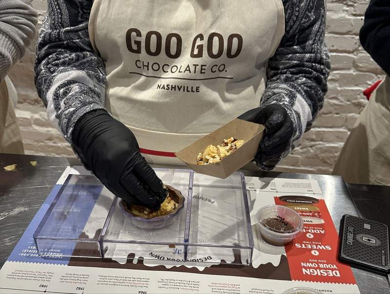 someone wearing black gloves working with food. 