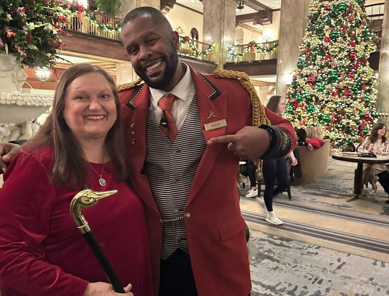 A man in a red uniform standing beside a woman dressed in red. 