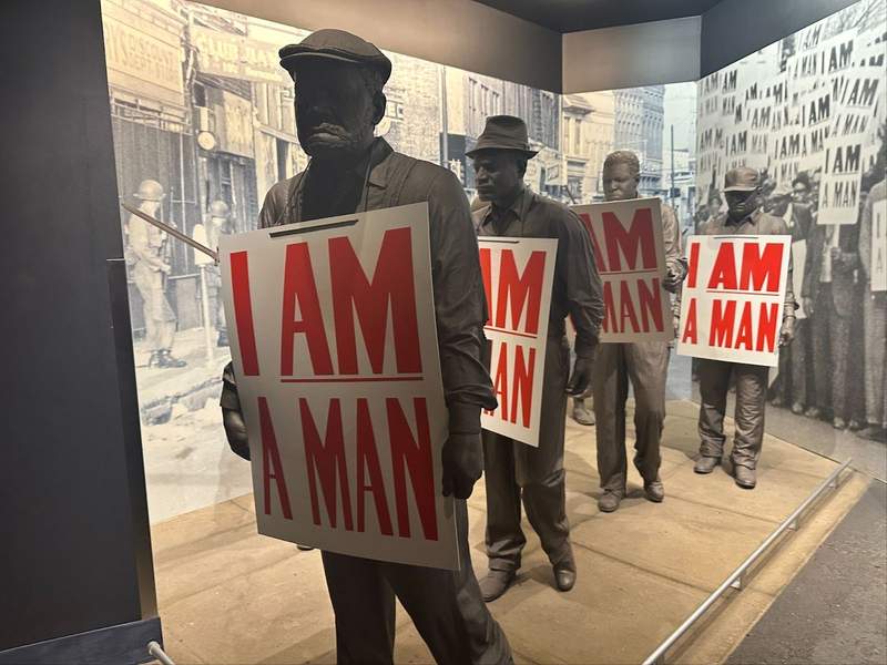 Four Statues hold signs.