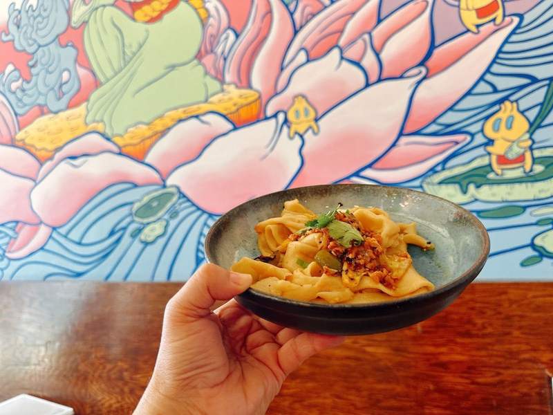 A dish of food in front of a colorful mural