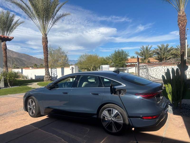 The Audi E6 in Palm Springs with palm trees and mountains.