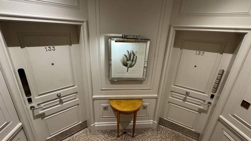 Two beige doors of connecting rooms in a small corridor at The Stafford London. 