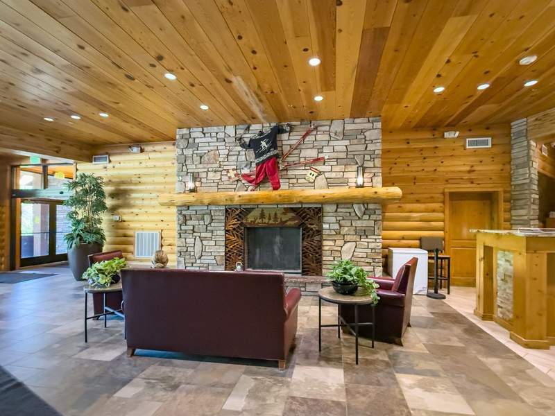 Lobby with pine logs fireplace and seating with ski motif.