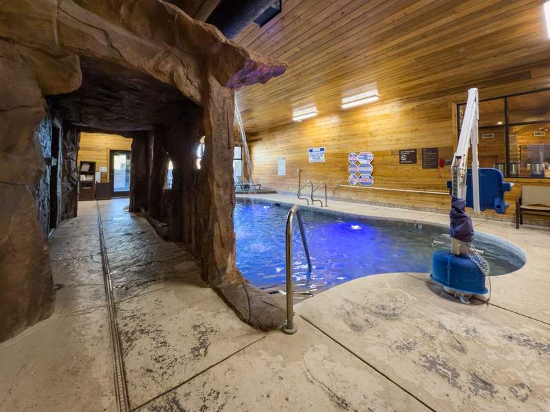 Indoor swimming pool with covered hallway and handicapped accessible lift.