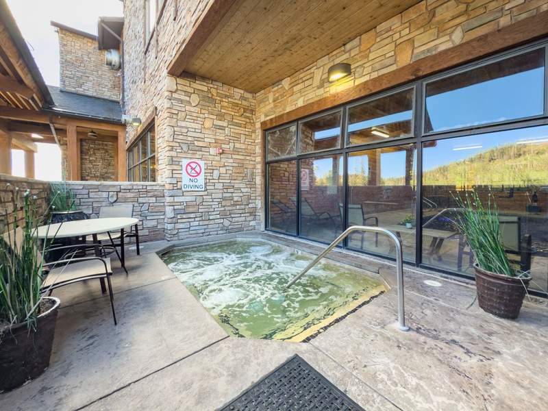 Courtyard with table and chairs features the outdoor bubbling hot tub.