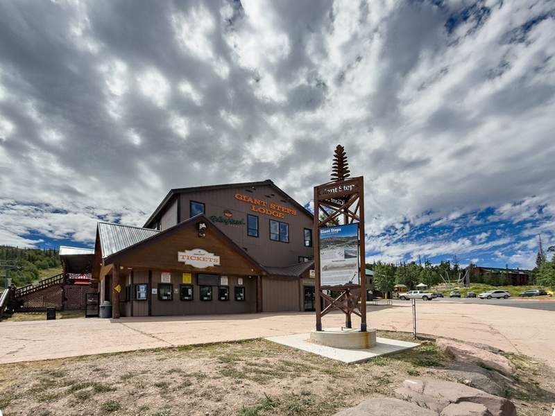 Tickets sign on Giant Steps Lodge from large parking lot.