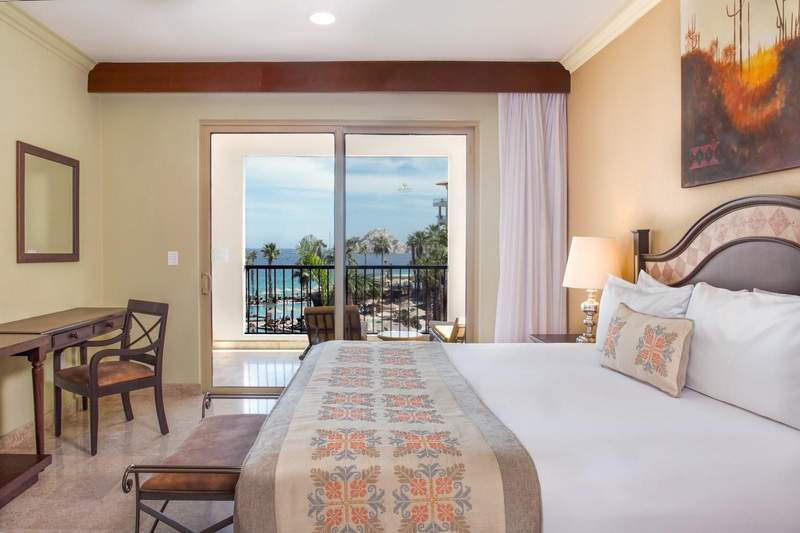 Large bed with balcony in the background.