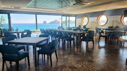 Restaurant tables and chairs with El Arco in the distance.