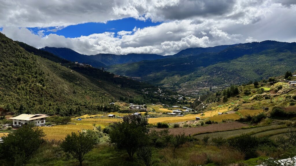 Bhutanese landscape with mountains, valleys and a blue sky with white clouds.