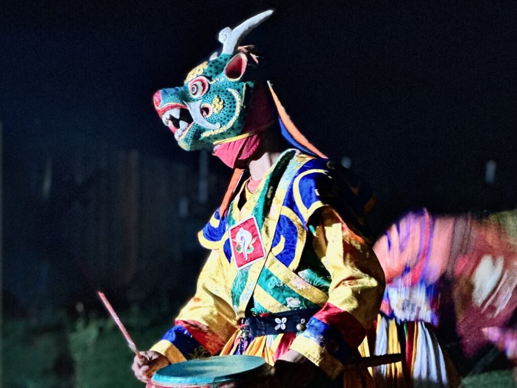 Colorfully-dressed dancer with mask at night in Bhutan.