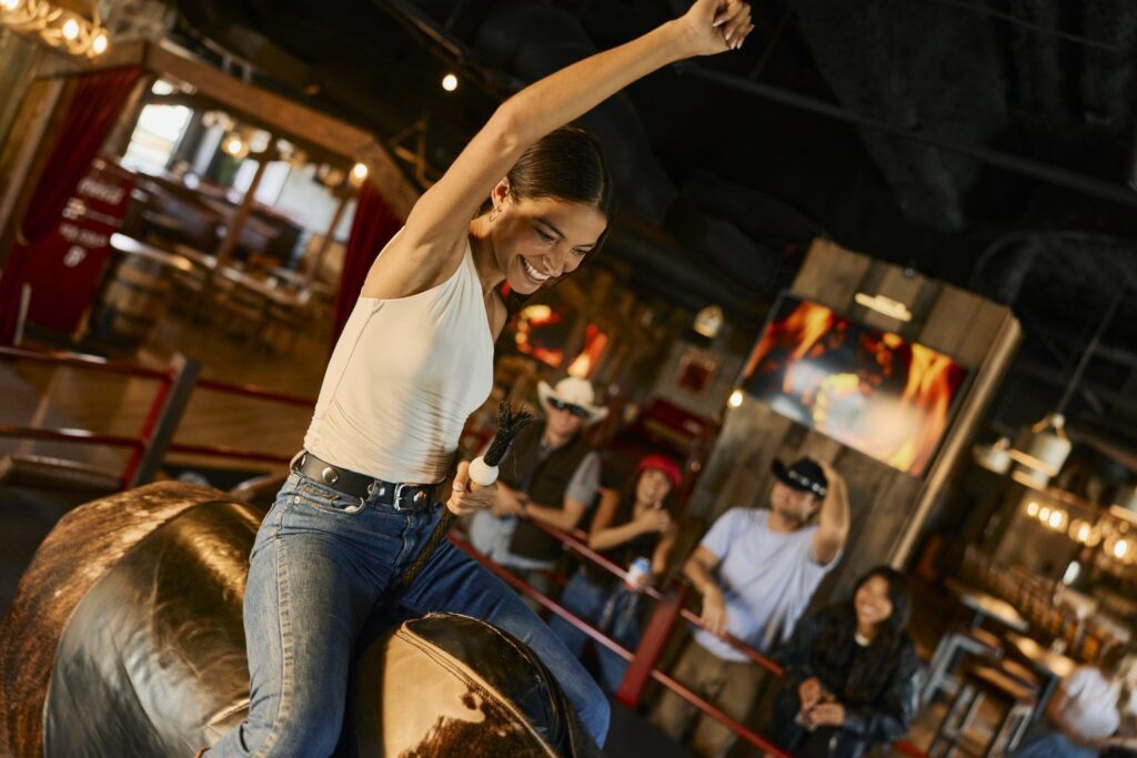Woman having fun riding a mechanical bull at Westwood Coast.