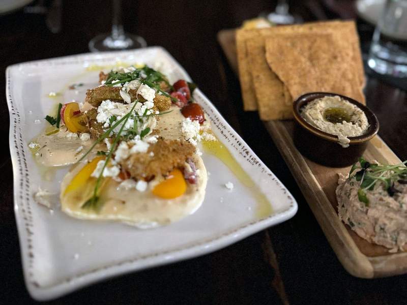 Two small appetizers on a table at a restaurant.