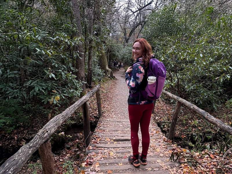 A woman wearing a backpack on a trail in the Great Smoky Mountains National Park.