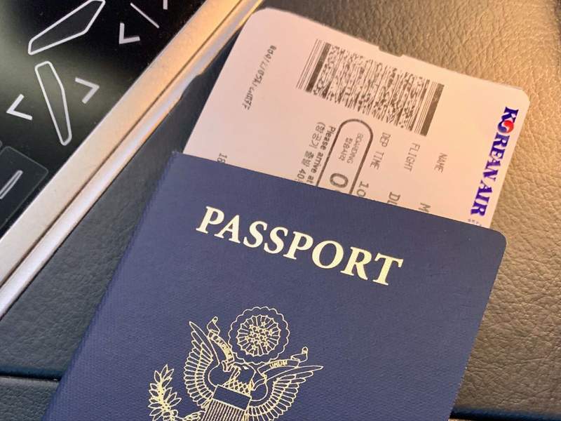 Blue passport with airplane ticket