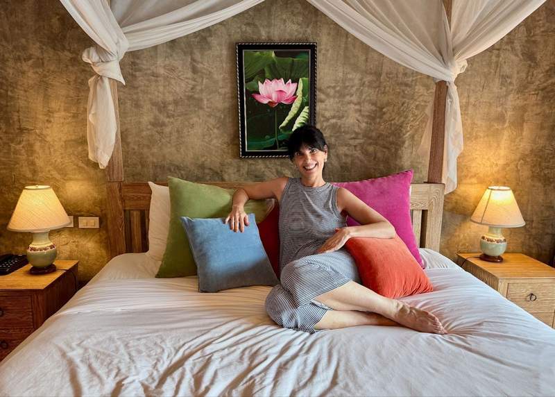 Woman on bed with colorful pillows